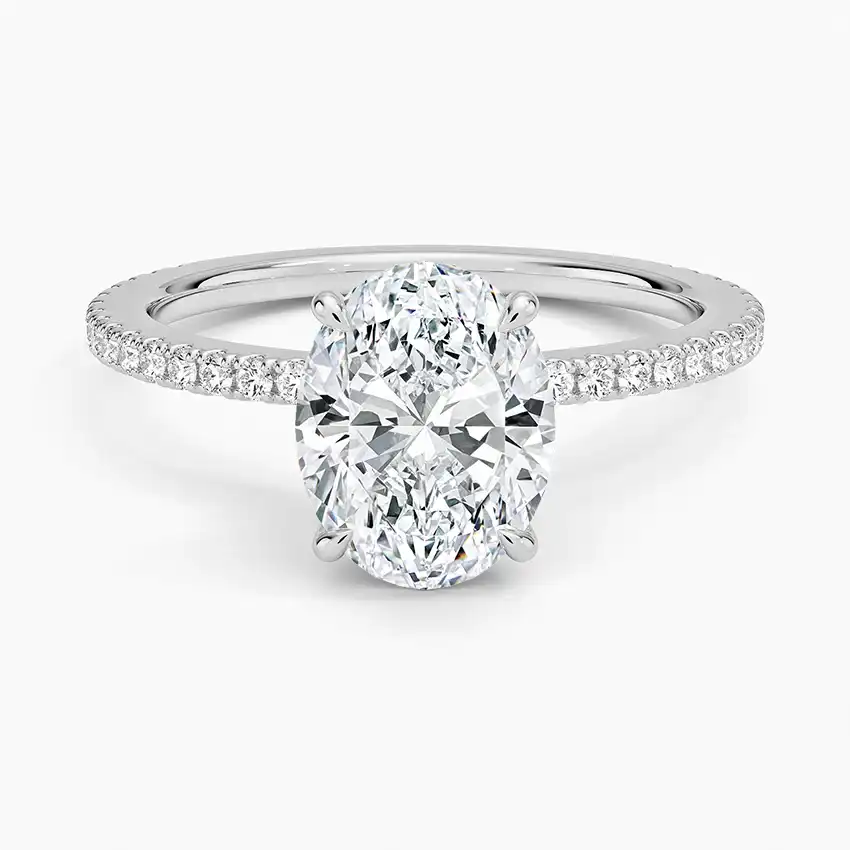 Oval moissanite engagement ring with pavé band on white background