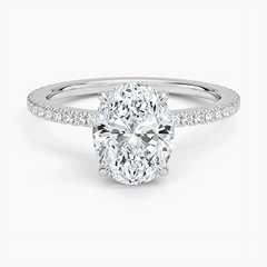 Oval moissanite engagement ring with pavé band on white background