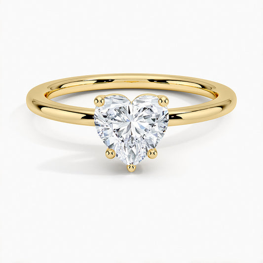Heart-shaped moissanite solitaire ring with gold band on white background