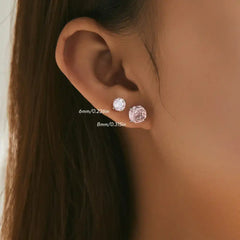 Woman wearing two moissanite stud earrings in 6mm and 8mm sizes on ear lobe