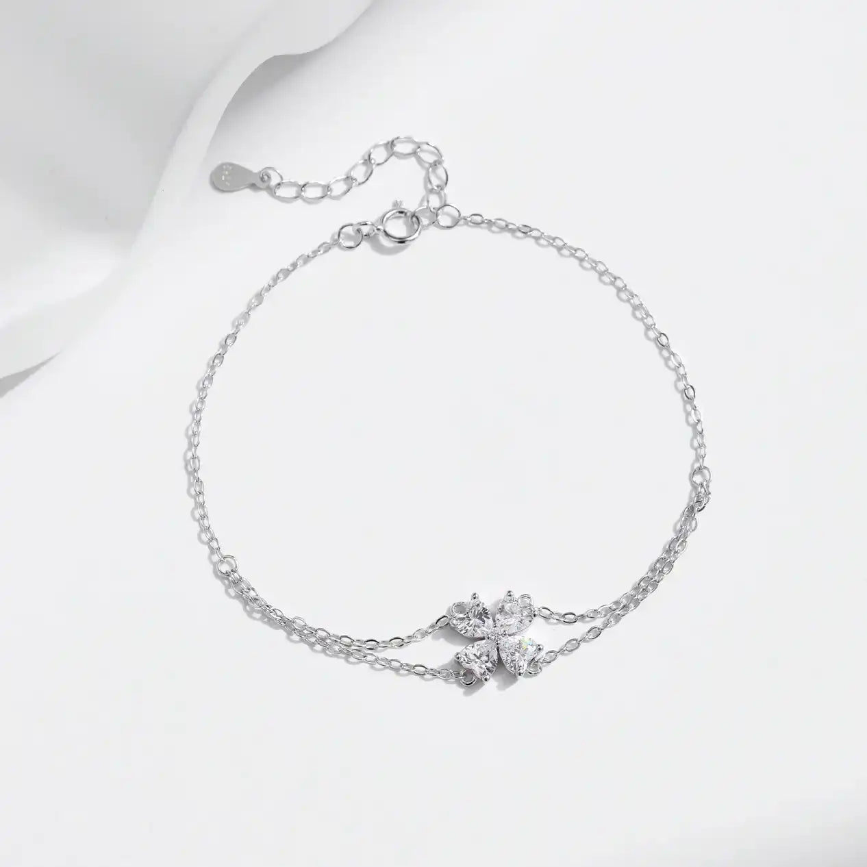 Delicate moissanite flower bracelet with silver chain on white background