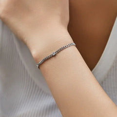 Minimalist moissanite tennis bracelet on wrist, silver chain, elegant jewelry for women