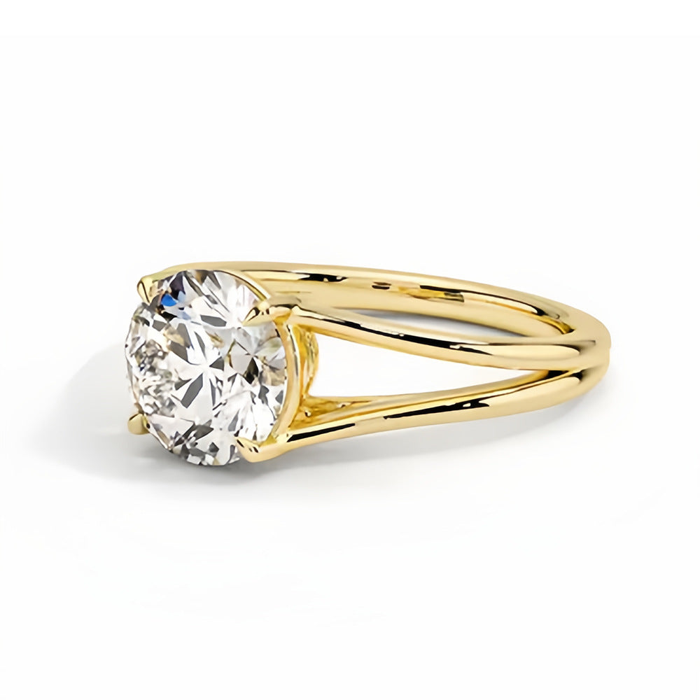 Round moissanite solitaire ring with split shank yellow gold band on white background
