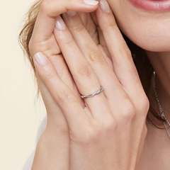 Hand wearing a twisted moissanite band ring, showcasing fine jewelry details