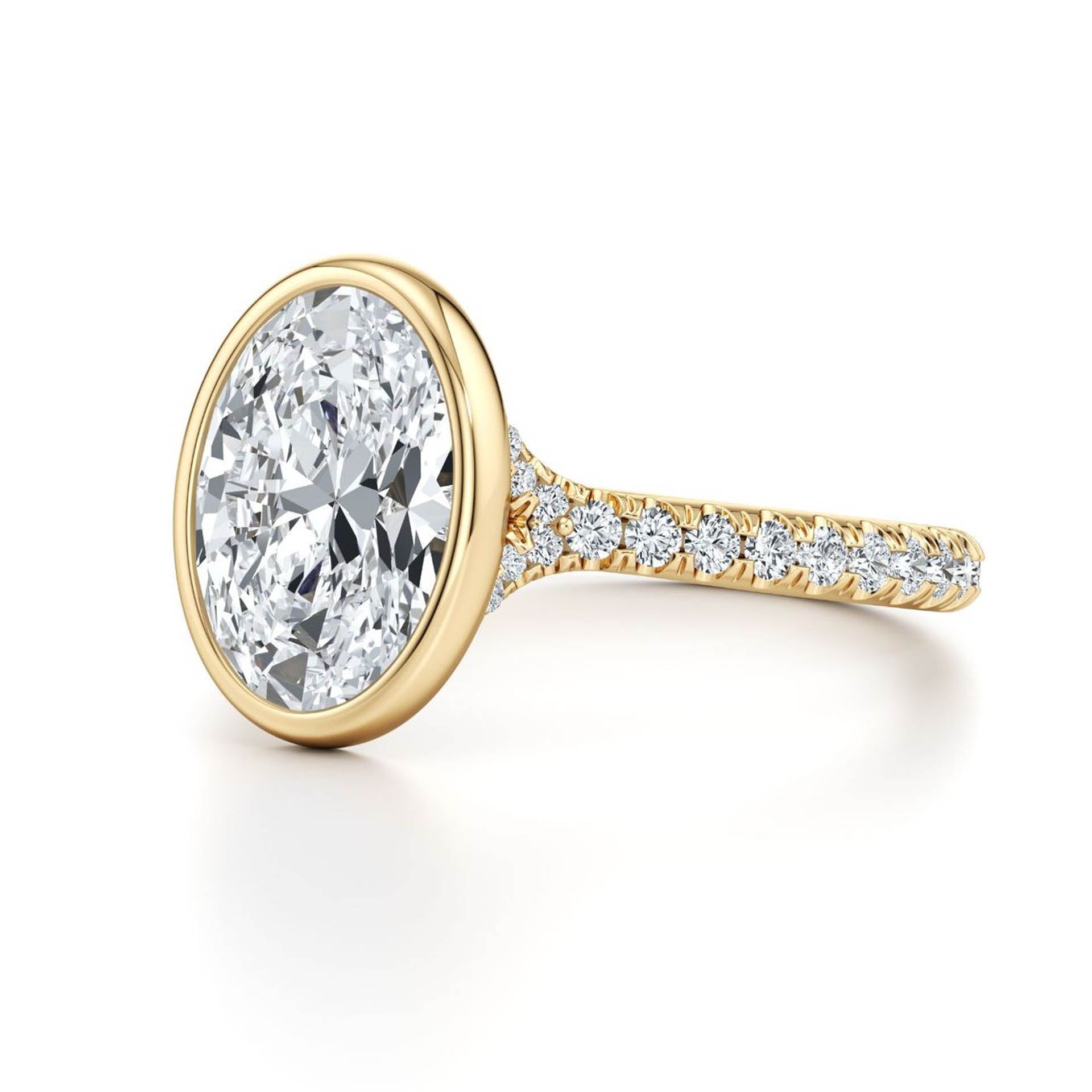 Oval moissanite engagement ring with diamond pavé on gold band on white background.