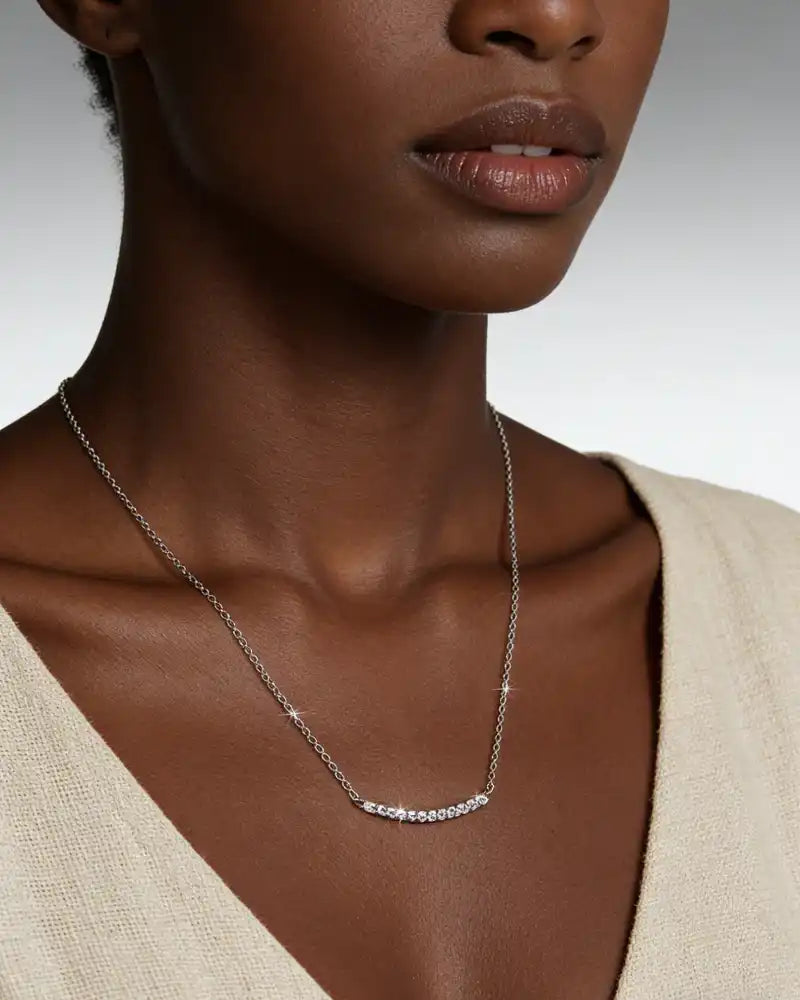 Woman wearing a moissanite bar necklace on a delicate silver chain