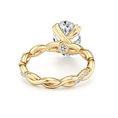 Gold braided ring with moissanite stones and large solitaire oval gemstone on white background