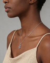 Woman wearing a sparkling moissanite pendant necklace on a silver chain, close-up view