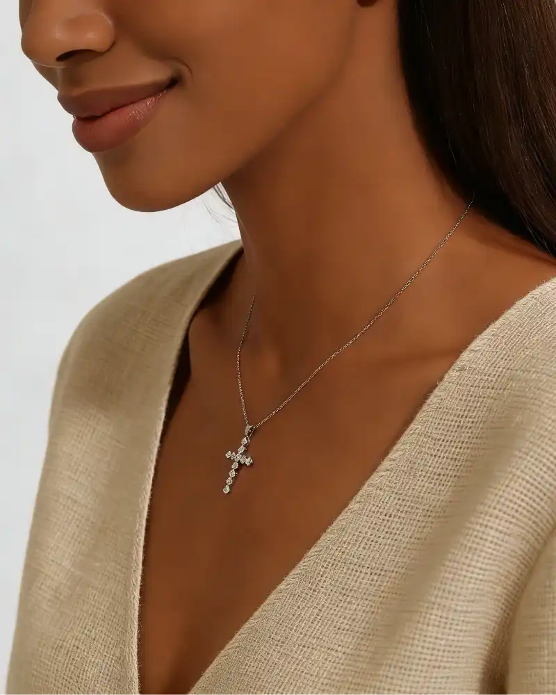 Woman wearing a moissanite cross pendant necklace on a silver chain