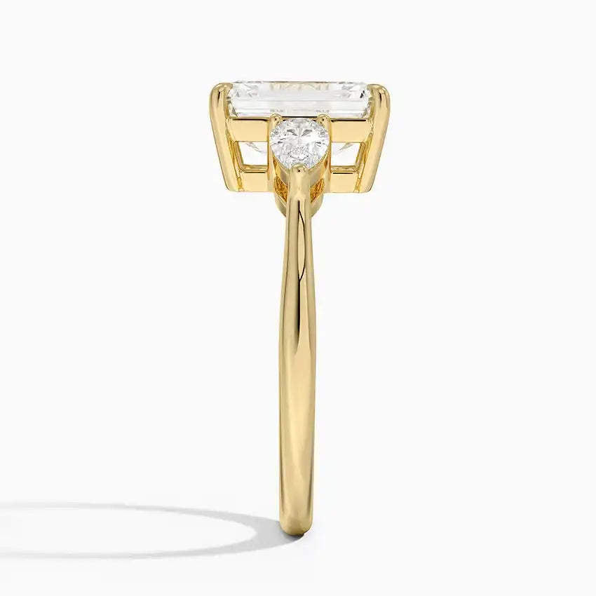 Yellow gold ring with emerald-cut moissanite center stone, side profile view