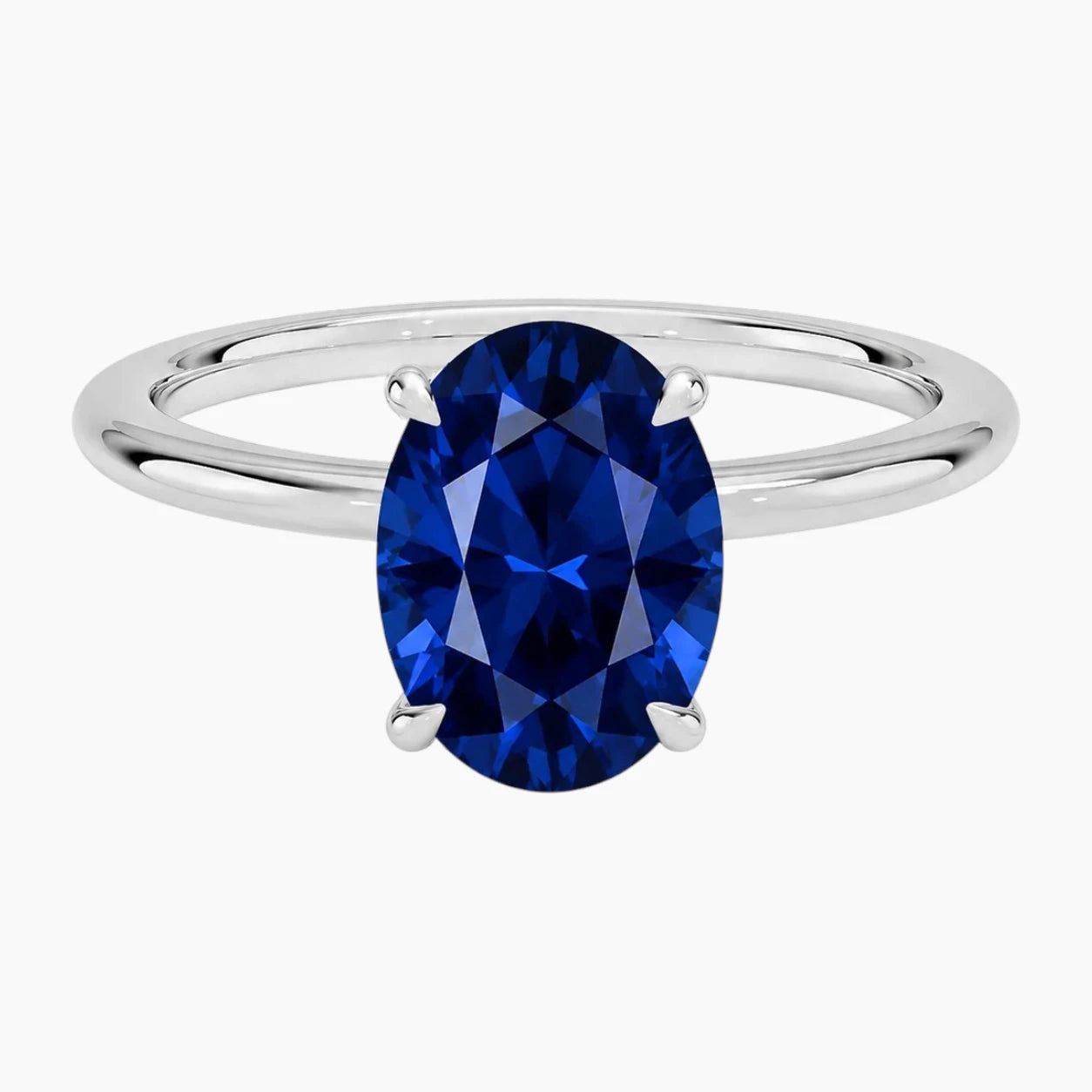 Top-down view of a classic 2-carat oval-cut lab-grown sapphire ring set in a polished 18K white gold-plated band.