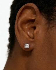 Close-up of ear wearing a round moissanite stud earring in a four-prong setting