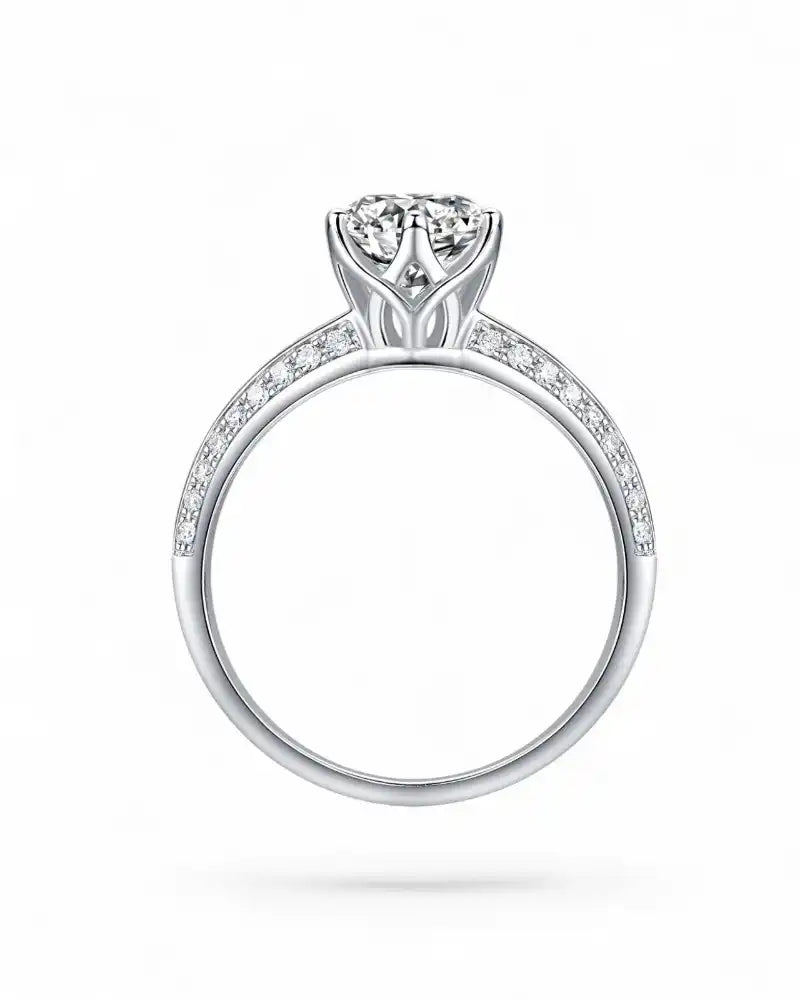 Side view of a silver moissanite engagement ring with pavé band and brilliant center stone