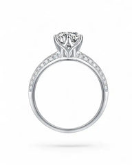 Side view of a silver moissanite engagement ring with pavé band and brilliant center stone