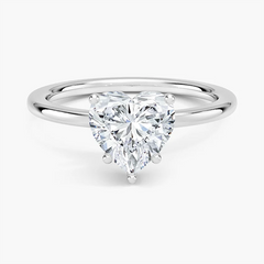 Heart shaped moissanite solitaire ring with a silver band on white background