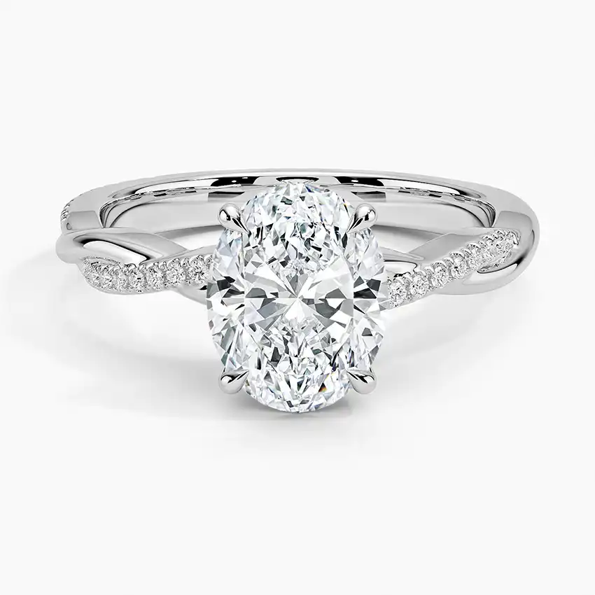 Oval cut moissanite engagement ring with twisted diamond pavé band in white metal