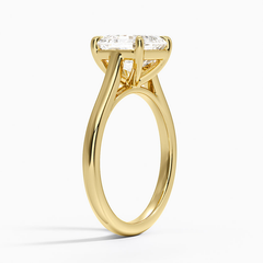 Gold solitaire ring with round moissanite center stone on a plain band
