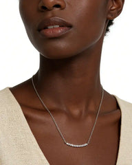 Woman wearing a moissanite bar pendant necklace on a silver chain