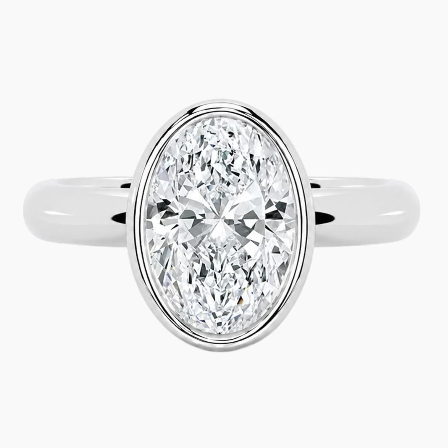 Oval bezel moissanite ring featuring a brilliant oval-cut stone and polished 2.6mm yellow gold comfort-fit band.