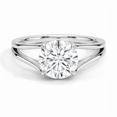 Round cut moissanite solitaire ring with split shank in polished white metal