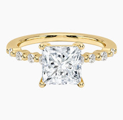 Princessl-cut moissanite ring featuring an 18K white gold-plated band set with pavé diamonds; an elegant solitaire-style engagement ring.