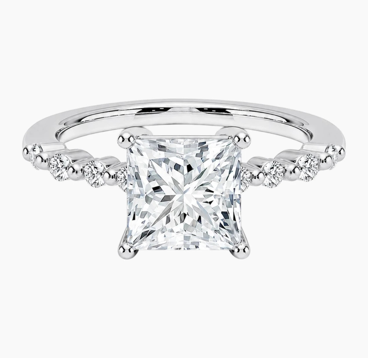 Princessl-cut moissanite ring featuring an 18K white gold-plated band set with pavé diamonds; an elegant solitaire-style engagement ring.