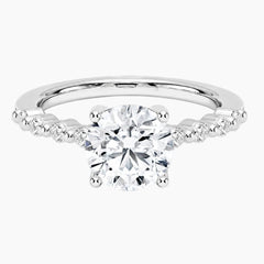 Round-cut moissanite ring featuring an 18K white gold-plated band set with pavé diamonds; an elegant solitaire-style engagement ring