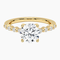 Round-cut moissanite ring featuring an 18K white gold-plated band set with pavé diamonds; an elegant solitaire-style engagement ring.