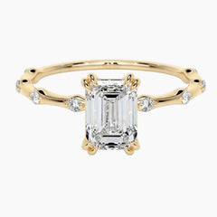 Yellow gold moissanite engagement ring with side accent stones on white background