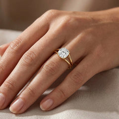 Hand wearing a gold moissanite engagement ring with large round brilliant stone
