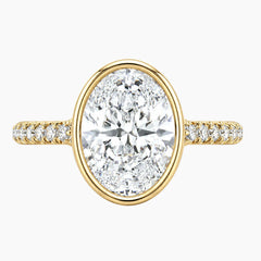 Oval moissanite engagement ring with gold band and pavé accent stones