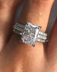Radiant cut moissanite engagement ring with pavé band set on a woman's hand