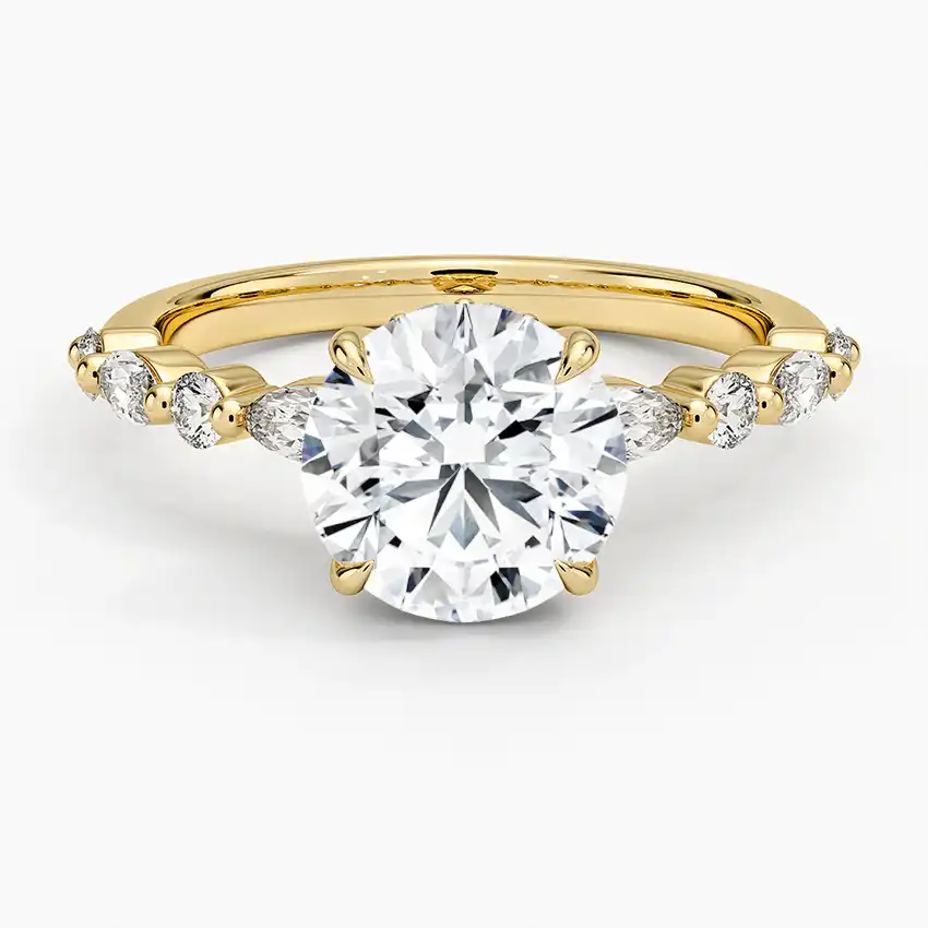 Round moissanite engagement ring with side stones on yellow gold band