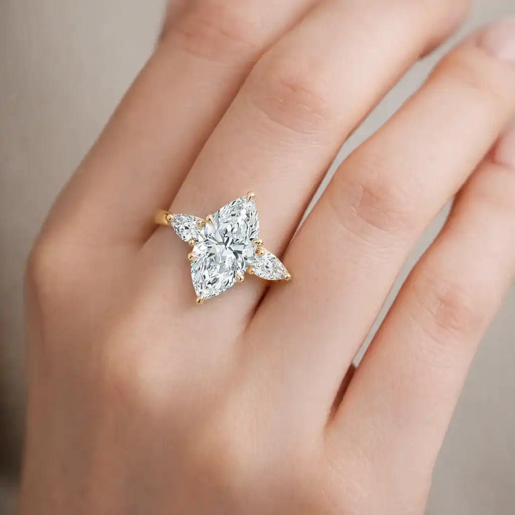 Gold ring with four marquise-cut moissanite stones on a woman's hand