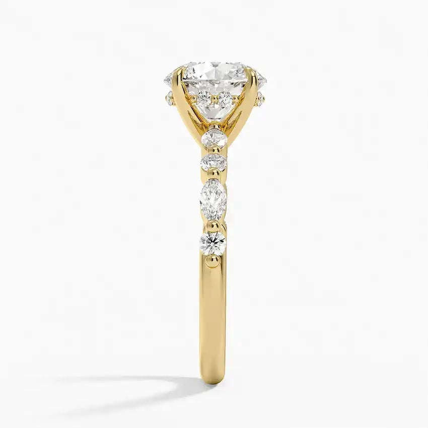 Gold moissanite engagement ring with round and marquise stones on band, side view