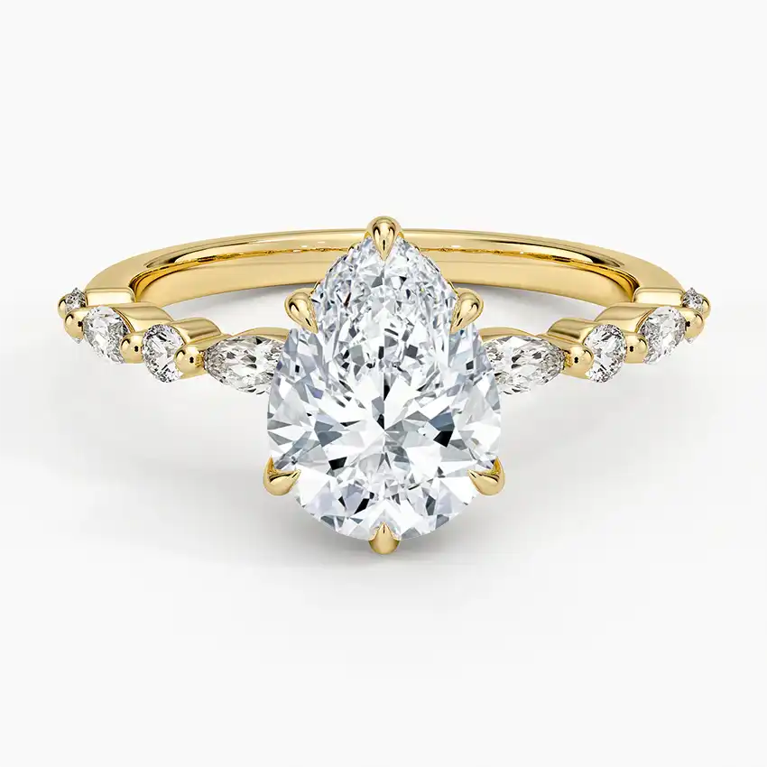 Pear-shaped moissanite ring with side stones on a yellow gold band