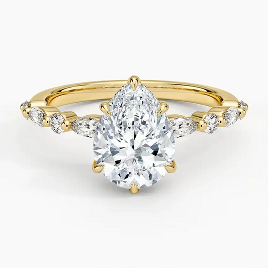 Pear-shaped moissanite ring with side stones on a yellow gold band