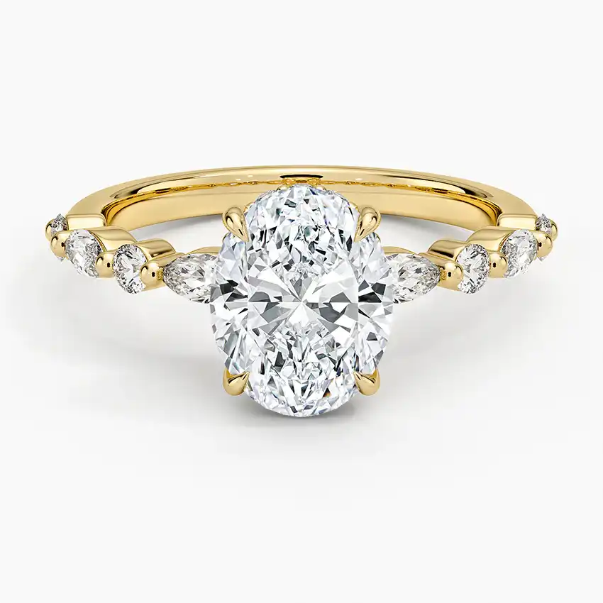 Oval moissanite engagement ring with side stones set on a yellow gold band
