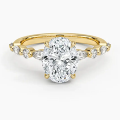 Oval moissanite engagement ring with side stones set on a yellow gold band