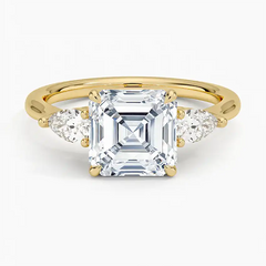 Asscher cut moissanite ring in yellow gold with pear side stones, elegant jewelry