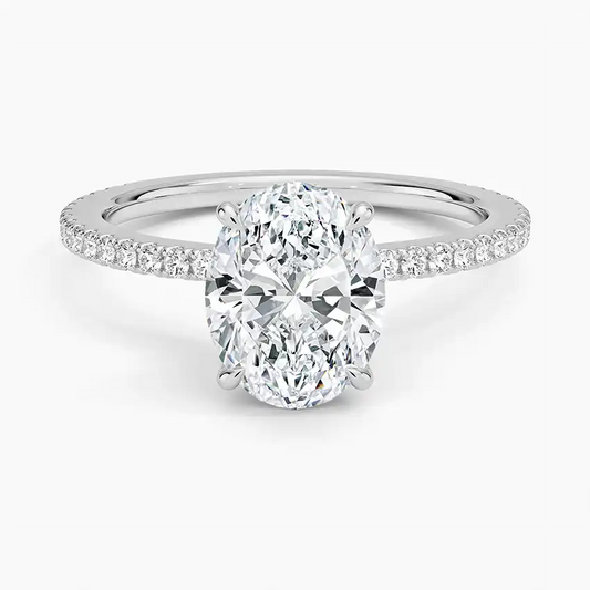 Oval moissanite engagement ring with pavé band on white background