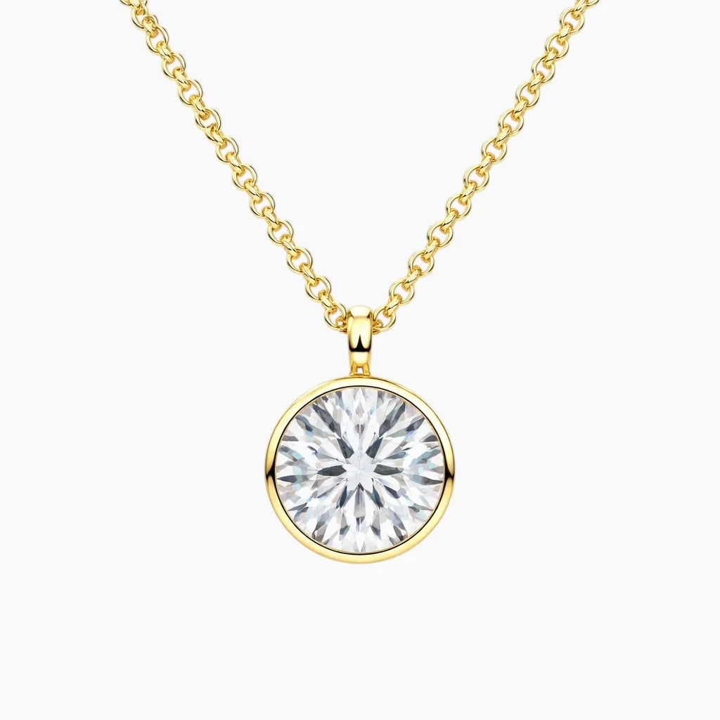 Gold chain necklace with round brilliant moissanite solitaire pendant on white background
