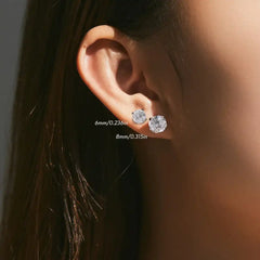 Close up of ear wearing two round moissanite stud earrings, 6mm and 8mm sizes