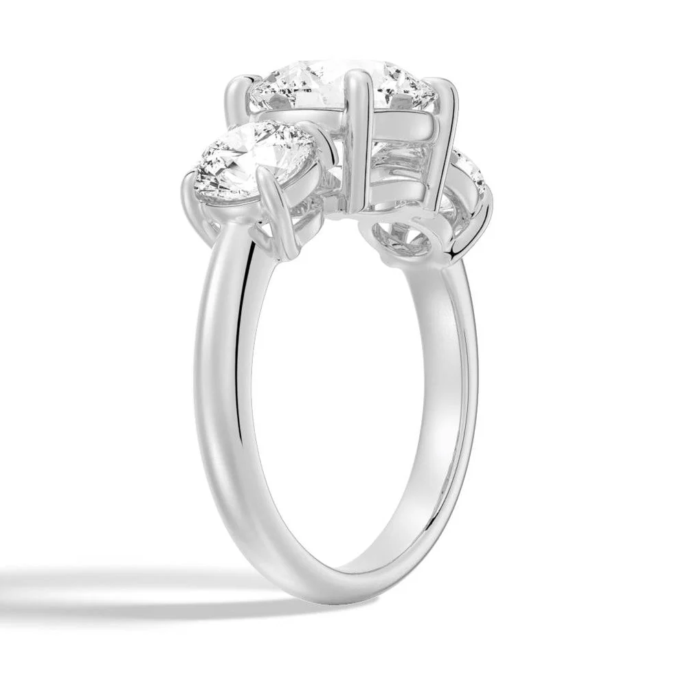 Three stone moissanite engagement ring with round gemstones in a silver prong setting