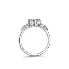 Side view of a moissanite engagement ring with a central stone and smaller accent stones on a silver band