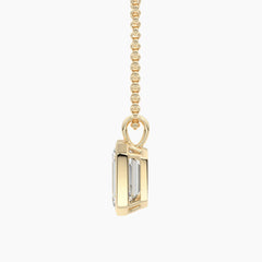 Gold chain necklace with a rectangular moissanite pendant, side profile view