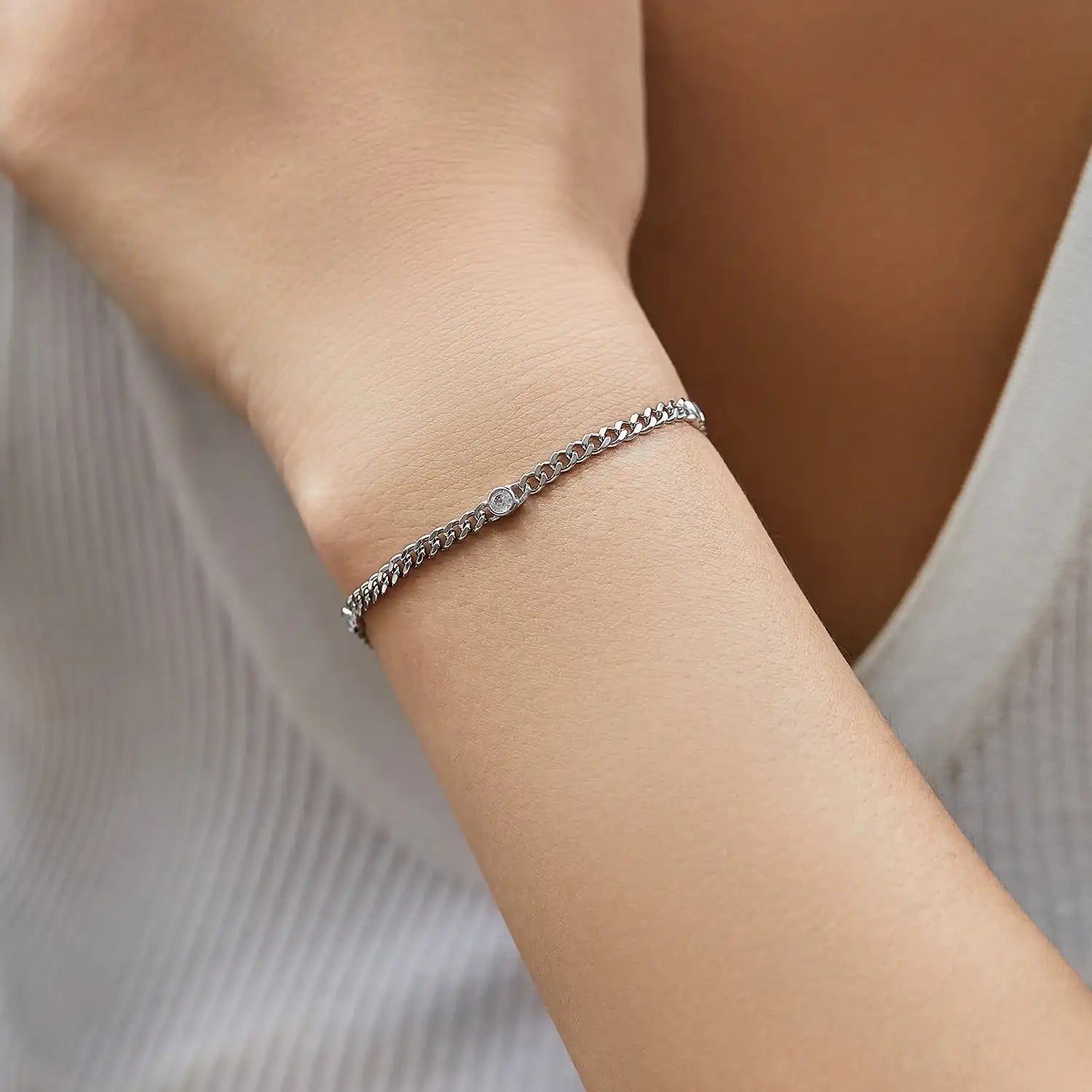 Minimalist moissanite tennis bracelet on wrist, silver chain, elegant jewelry for women