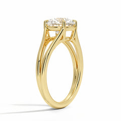 Gold solitaire ring with round brilliant moissanite gemstone on white background