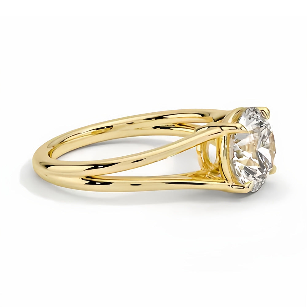 Round moissanite solitaire ring with split shank yellow gold band on white background