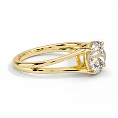 Round moissanite solitaire ring with split shank yellow gold band on white background